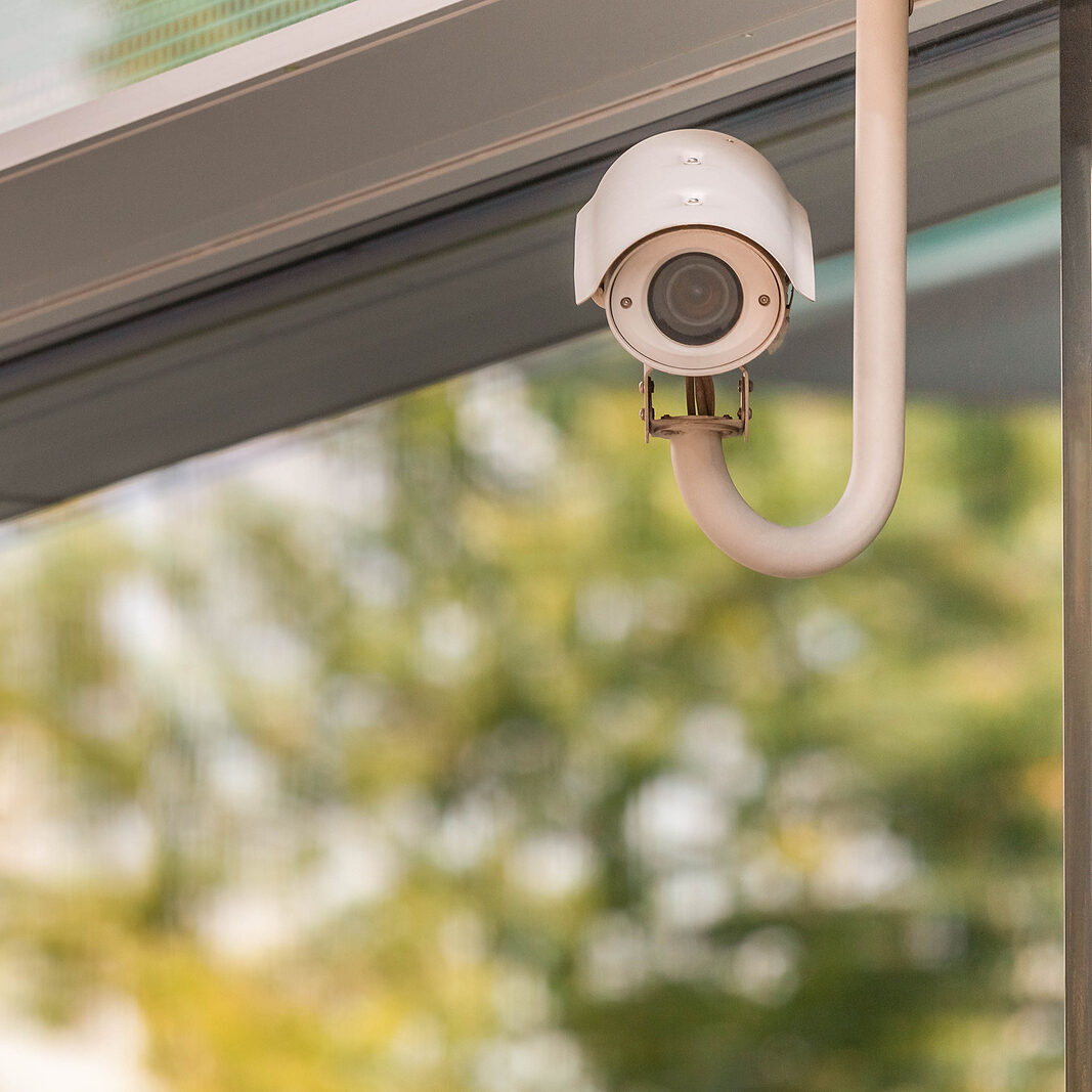 Outdoor Cctv Surveillance Camera On Building Window In Green Tre WE GIVE YOU PEACE OF MIND & HELP REDUCE YOUR COMMERCIAL INSURANCE RATES